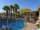 Backyard pool featuring palm trees and a covered patio, perfect for outdoor living at 7524 Midnight Rambler St, Las Vegas, NV 89149