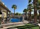 Backyard pool area with mature palm trees and an extended covered patio at 7524 Midnight Rambler St, Las Vegas, NV 89149