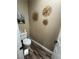 A small toilet room features sunflower-themed decor and modern fixtures at 7524 Midnight Rambler St, Las Vegas, NV 89149