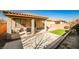 A covered patio with a grill and a small patch of artificial turf in backyard at 766 Topocoba St, Las Vegas, NV 89178