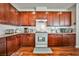 Beautiful kitchen featuring dark wood cabinetry, granite counters, and white appliances at 766 Topocoba St, Las Vegas, NV 89178