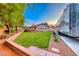 Expansive backyard with lush green lawn, mature tree, and RV parking on driveway at 7670 Descanso Ln, Las Vegas, NV 89123