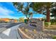 Welcoming entrance to Frontier Estates with stone signage, lush landscaping, and security gate at 7670 Descanso Ln, Las Vegas, NV 89123