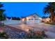 Wide driveway leading to a two-car garage, complemented by desert landscaping and a secure gate at 7670 Descanso Ln, Las Vegas, NV 89123