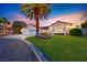 Charming single-story home featuring a well-manicured lawn, mature palm trees, and a three-car garage at 7670 Descanso Ln, Las Vegas, NV 89123