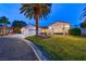 Charming single-story home with a well-manicured lawn and a towering palm tree in the front yard at 7670 Descanso Ln, Las Vegas, NV 89123