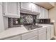 Kitchen counter featuring black backsplash, kitchen utensils decor, and stainless cooktop at 7670 Descanso Ln, Las Vegas, NV 89123