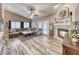 Spacious living room featuring a stone fireplace, wood-look floors, and large sectional sofa at 7670 Descanso Ln, Las Vegas, NV 89123