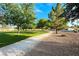 Picturesque view of park with large trees, grassy area, and paved walkway at 7670 Descanso Ln, Las Vegas, NV 89123