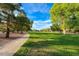 Beautiful park with lush green grass, mature trees, and winding walking path at 7670 Descanso Ln, Las Vegas, NV 89123