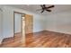 A bright bedroom with wood floors, ceiling fan and door to another room at 7950 Red Barn Dr, Las Vegas, NV 89123