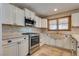 Kitchen boasts stainless steel appliances, white cabinets, and ample counter space at 7950 Red Barn Dr, Las Vegas, NV 89123