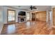 Bright living room featuring wood floors, a brick fireplace, and a ceiling fan at 7950 Red Barn Dr, Las Vegas, NV 89123