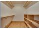 The walk-in closet has built-in shelving on the sides and a wood floor at 7950 Red Barn Dr, Las Vegas, NV 89123