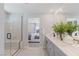 Bright bathroom featuring a double vanity with modern fixtures and a glass-enclosed shower and tub at 7983 Texas Hills St, Las Vegas, NV 89113