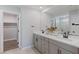 Modern bathroom with double vanity, grey cabinets, and walk-in closet access at 7983 Texas Hills St, Las Vegas, NV 89113