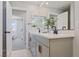 Well-lit bathroom featuring a double vanity, sleek modern fixtures, and a glimpse into the main bedroom at 7983 Texas Hills St, Las Vegas, NV 89113