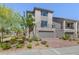 Contemporary two-story home with a stone facade, landscaped yard, balcony, and brick driveway at 7983 Texas Hills St, Las Vegas, NV 89113