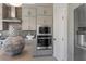 Close-up of the modern kitchen with gray cabinets, stainless steel appliances, and a tiled backsplash at 7983 Texas Hills St, Las Vegas, NV 89113