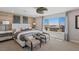 Bright main bedroom showcasing a wood accent wall, modern decor, and a large window with neighborhood views at 7983 Texas Hills St, Las Vegas, NV 89113