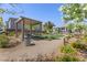 A shaded picnic table under a gazebo is surrounded by flowering plants and manicured lawn at 7983 Texas Hills St, Las Vegas, NV 89113