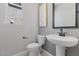 Bright powder room featuring modern fixtures, a pedestal sink, and wall decor at 7983 Texas Hills St, Las Vegas, NV 89113