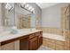 Elegant bathroom featuring a large vanity, soaking tub with tiled surround, and modern fixtures at 8717 Red Brook Dr # 201, Las Vegas, NV 89128