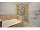 Modern bathroom featuring tiled walls, a glass-enclosed shower, and a soaking tub at 8717 Red Brook Dr # 201, Las Vegas, NV 89128