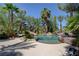 Backyard pool surrounded by tropical plants and trees with stone accents and lounging area at 8717 Red Brook Dr # 201, Las Vegas, NV 89128