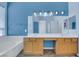 Bathroom featuring a double sink vanity and a soaking tub under a window at 8849 Pheasant Valley Way, Las Vegas, NV 89123