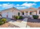 Inviting single-story home showcasing a two-car garage and manicured front yard with desert elements at 8849 Pheasant Valley Way, Las Vegas, NV 89123