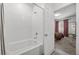 Bathroom with a white tub, a showerhead and an open door to the bedroom at 965 Nevada State Dr # 41201, Henderson, NV 89002