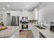 Bright kitchen with white cabinets, stainless steel appliances, a granite island and countertops, and wood-look flooring at 965 Nevada State Dr # 41201, Henderson, NV 89002
