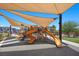 Community playground featuring multiple slides and play structures, with shade sails for sun protection during play at 965 Nevada State Dr # 41201, Henderson, NV 89002