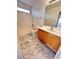 Well-lit bathroom boasts marble floors, vanity with storage, and a shower-tub combo at 9844 Ashton Pines Ct, Las Vegas, NV 89147