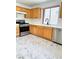Kitchen featuring stainless steel appliances, wood cabinets, and marble floors with stainless steel sink and faucet at 9844 Ashton Pines Ct, Las Vegas, NV 89147