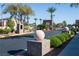 Gated community entrance with mature landscaping, palm trees, and decorative features at 10532 Redwood Ash Ave, Las Vegas, NV 89144