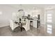Modern kitchen with stainless steel appliances, an island with bar stools, and adjacent dining area at 10532 Redwood Ash Ave, Las Vegas, NV 89144