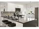 Kitchen island with bar seating and sleek countertops, featuring modern appliances at 10532 Redwood Ash Ave, Las Vegas, NV 89144