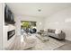 Bright living room featuring a modern fireplace, sleek furniture, and sliding glass door to the patio at 10532 Redwood Ash Ave, Las Vegas, NV 89144