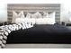 A close-up of a luxurious bed with a padded headboard and throw pillows at 10532 Redwood Ash Ave, Las Vegas, NV 89144