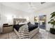 Bright main bedroom featuring a luxurious bed, neutral decor, and sliding door access to the outdoors at 10532 Redwood Ash Ave, Las Vegas, NV 89144