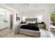Bright main bedroom featuring an en-suite bathroom, large bed and sliding door access to the outdoors at 10532 Redwood Ash Ave, Las Vegas, NV 89144
