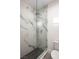 A modern walk-in shower with marble walls and black hexagonal floor tiles at 10532 Redwood Ash Ave, Las Vegas, NV 89144