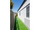 Side yard featuring artificial turf and a privacy fence, offering a clean and modern look at 10532 Redwood Ash Ave, Las Vegas, NV 89144