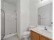 Clean bathroom featuring a walk-in shower, wood vanity, and tile flooring at 10642 Dawns Mist Ave, Las Vegas, NV 89129