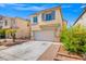 Charming two-story home featuring a two-car garage and low-maintenance desert landscaping under a bright blue sky at 10642 Dawns Mist Ave, Las Vegas, NV 89129