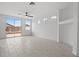 Bright living room featuring tile flooring, a ceiling fan, and sliding glass doors to the backyard at 10642 Dawns Mist Ave, Las Vegas, NV 89129