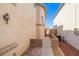 A narrow side yard featuring a white metal fence and access to the backyard at 10642 Dawns Mist Ave, Las Vegas, NV 89129