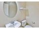 Powder room featuring a white sink, toilet, mirror, and shelf at 11816 Orense Dr, Las Vegas, NV 89138